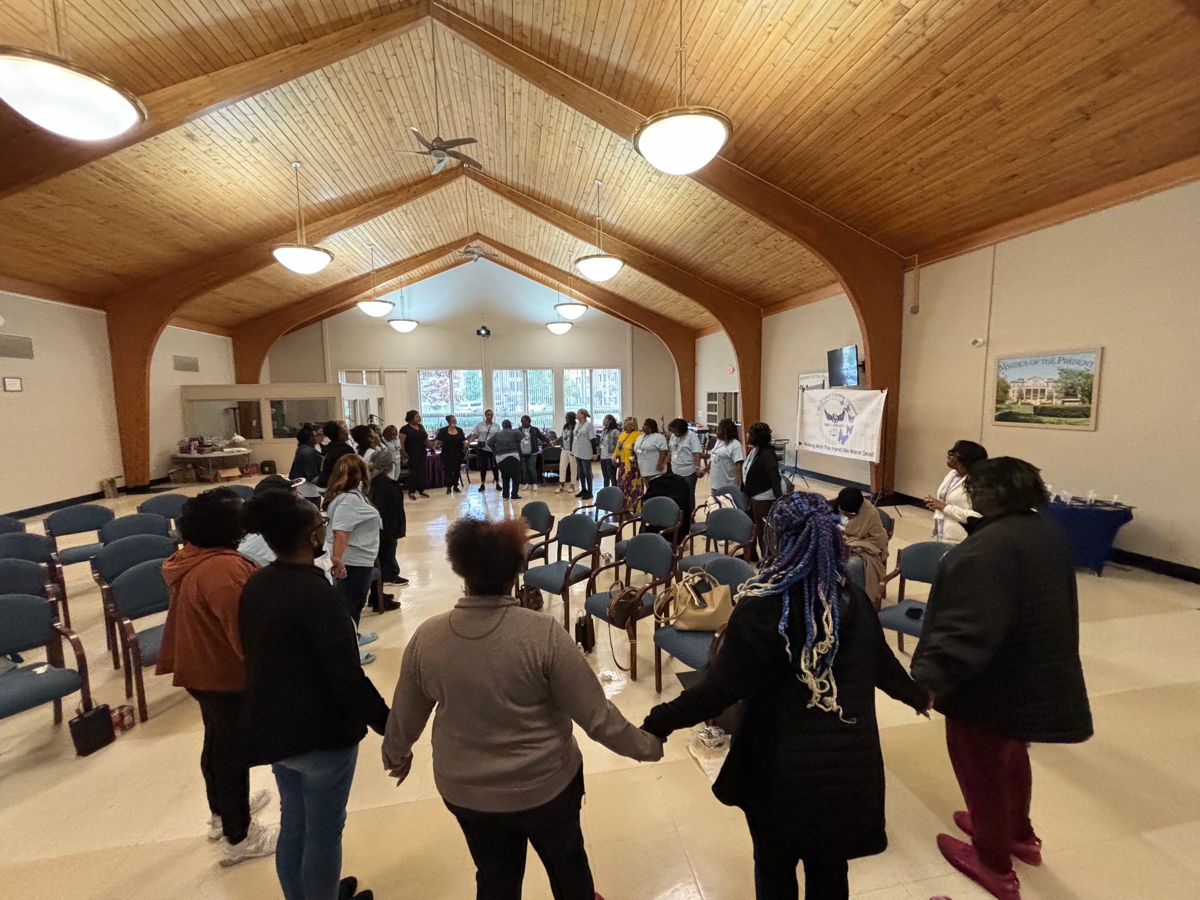 Large group holding hands in circle at ACE Healing Project gathering