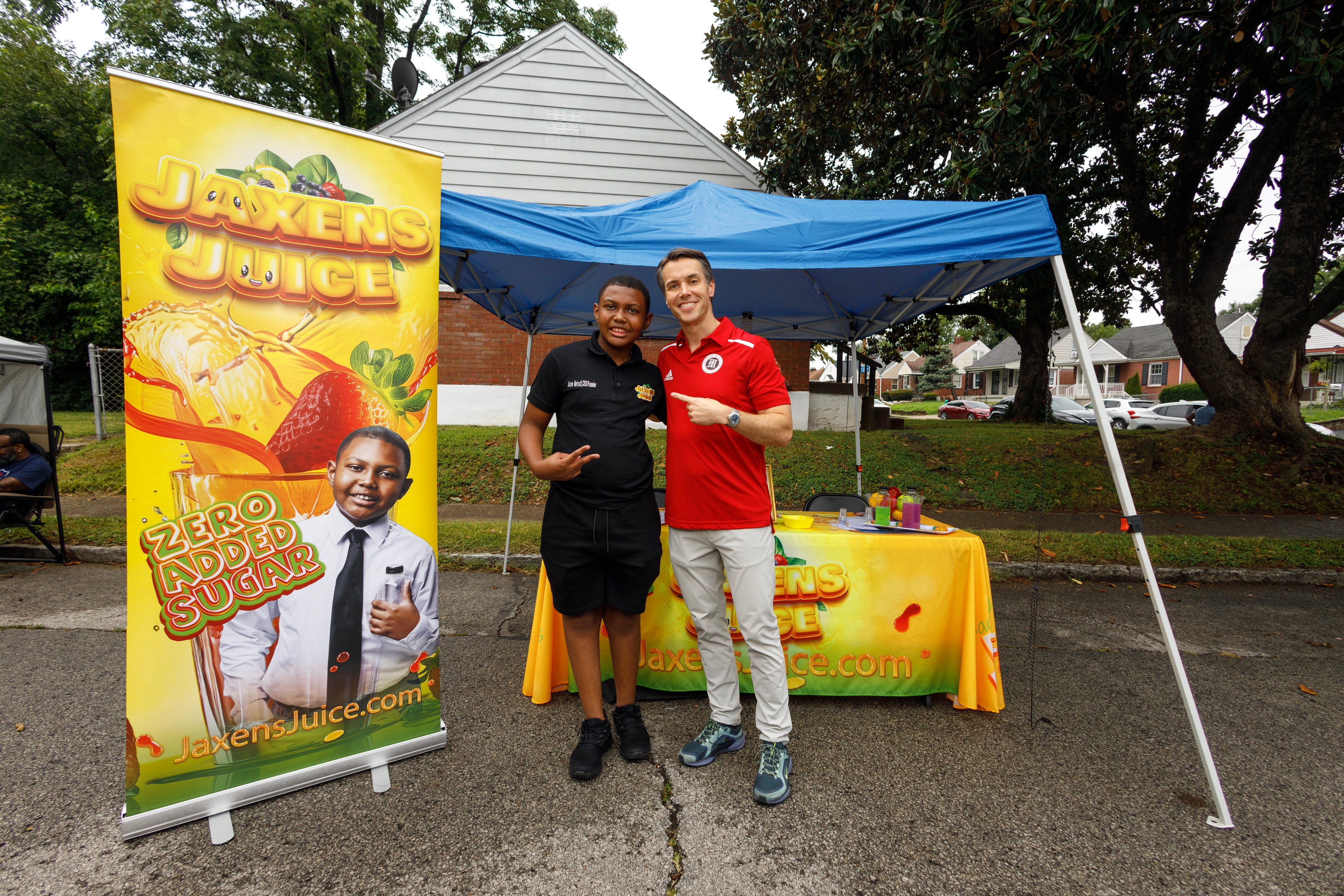 Youth entrepreneur and supporter at Jaxens Juice booth at ACE Way block party