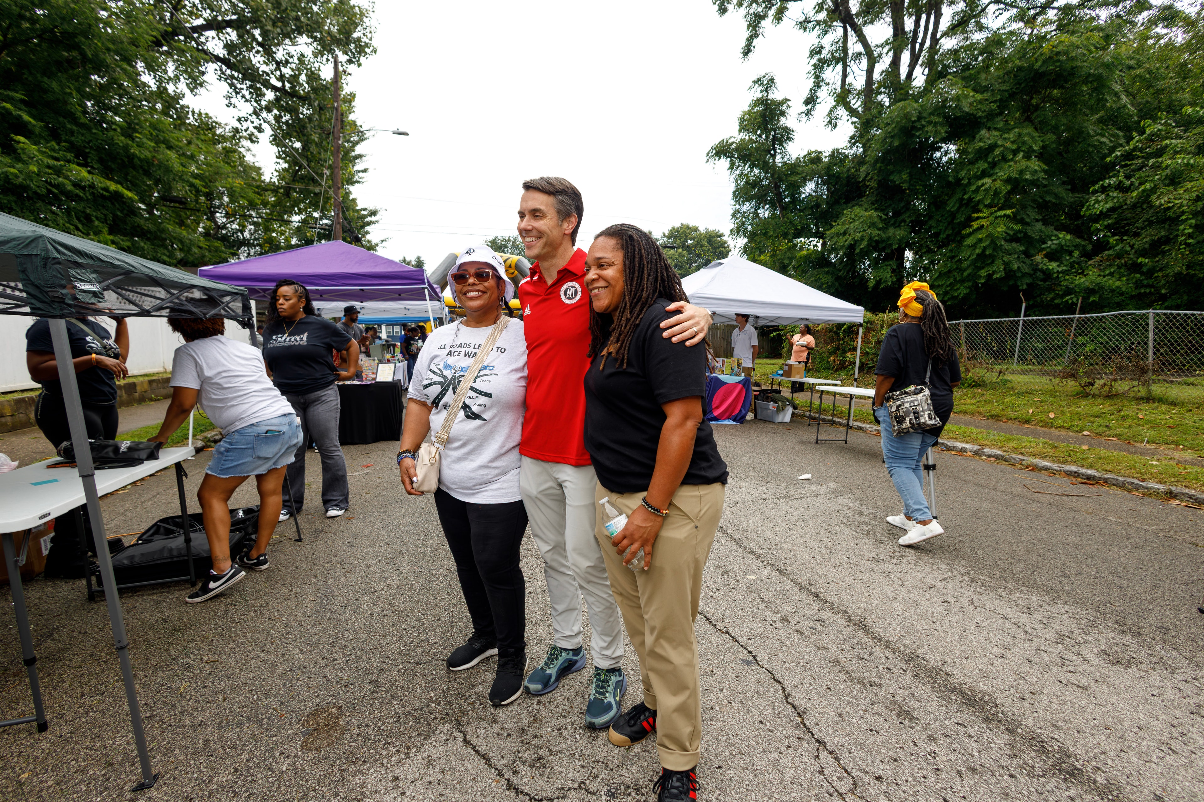 Three community members posing together at ACE Way block party vendor area