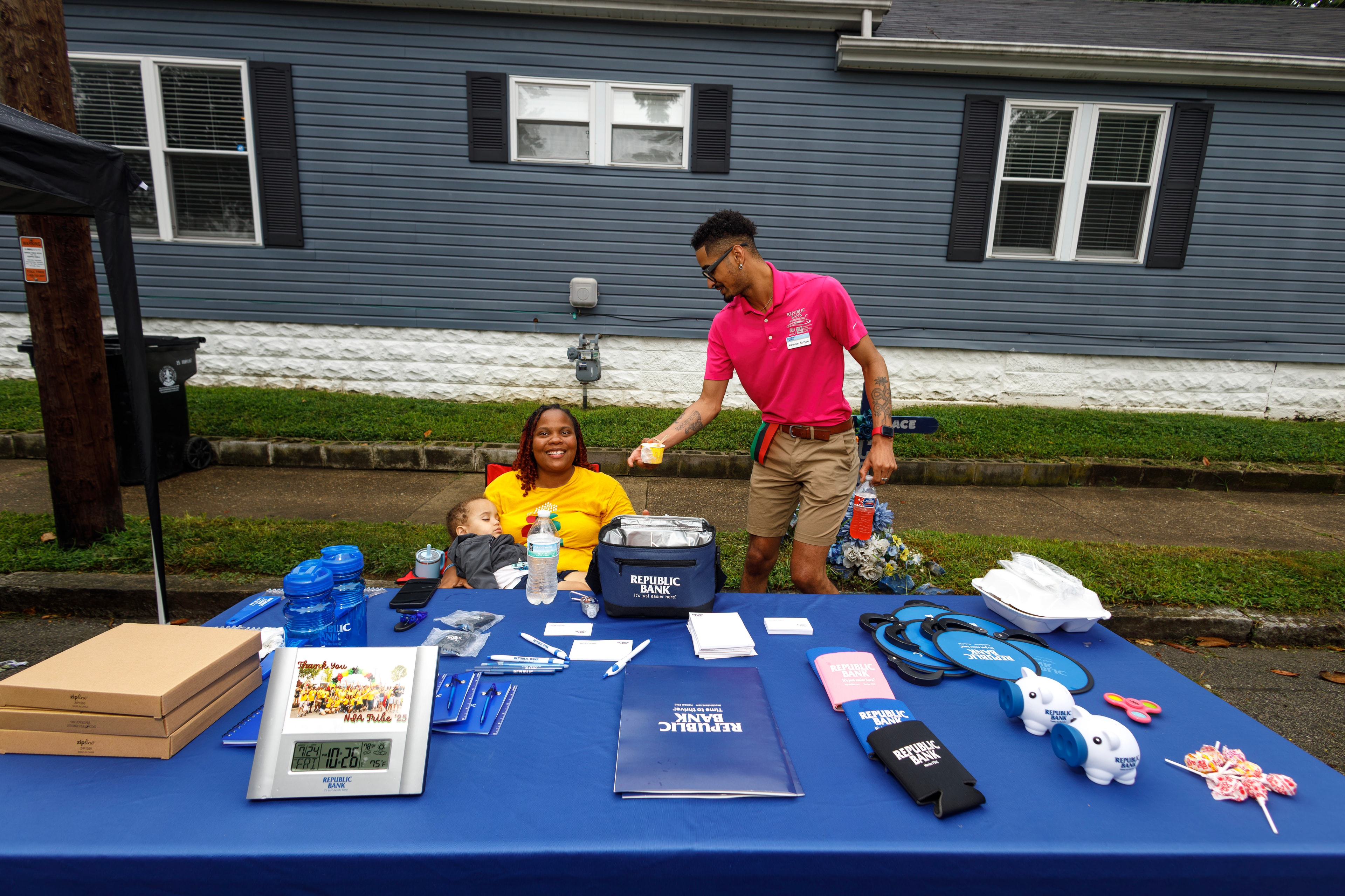 Volunteers at Republic Bank community outreach table at ACE Way block party