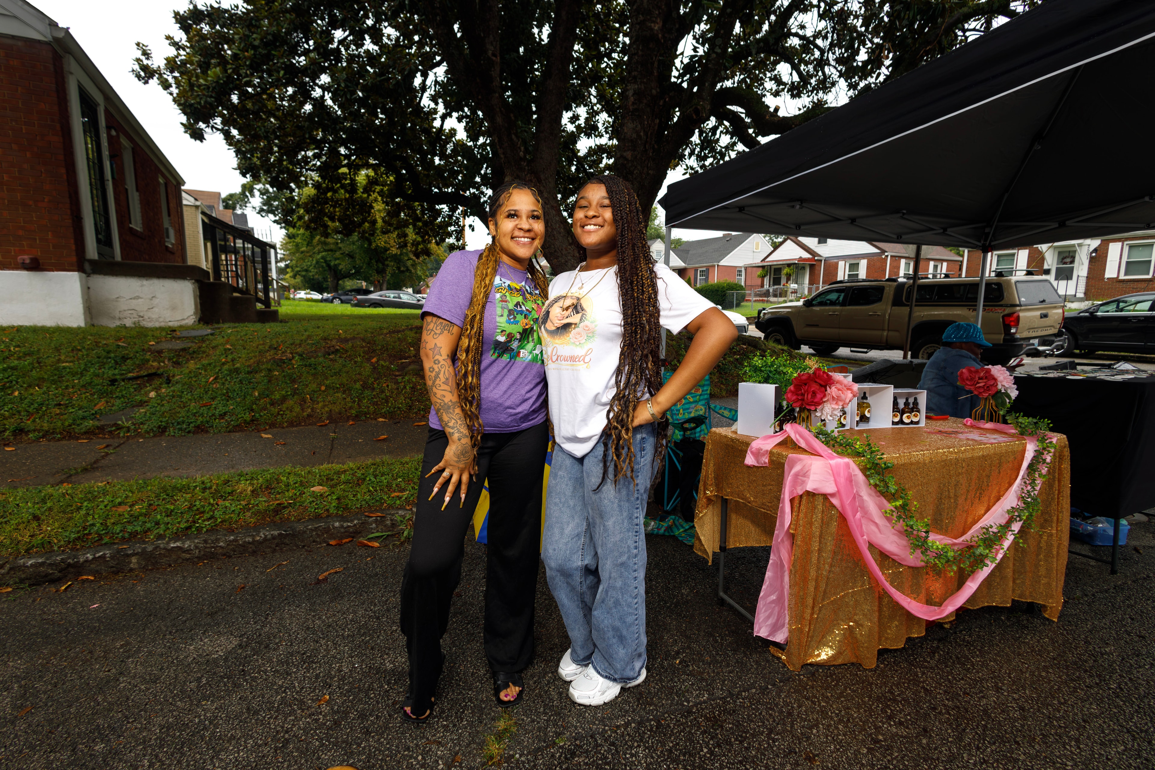 Two community members posing at vendor booth at ACE Way block party