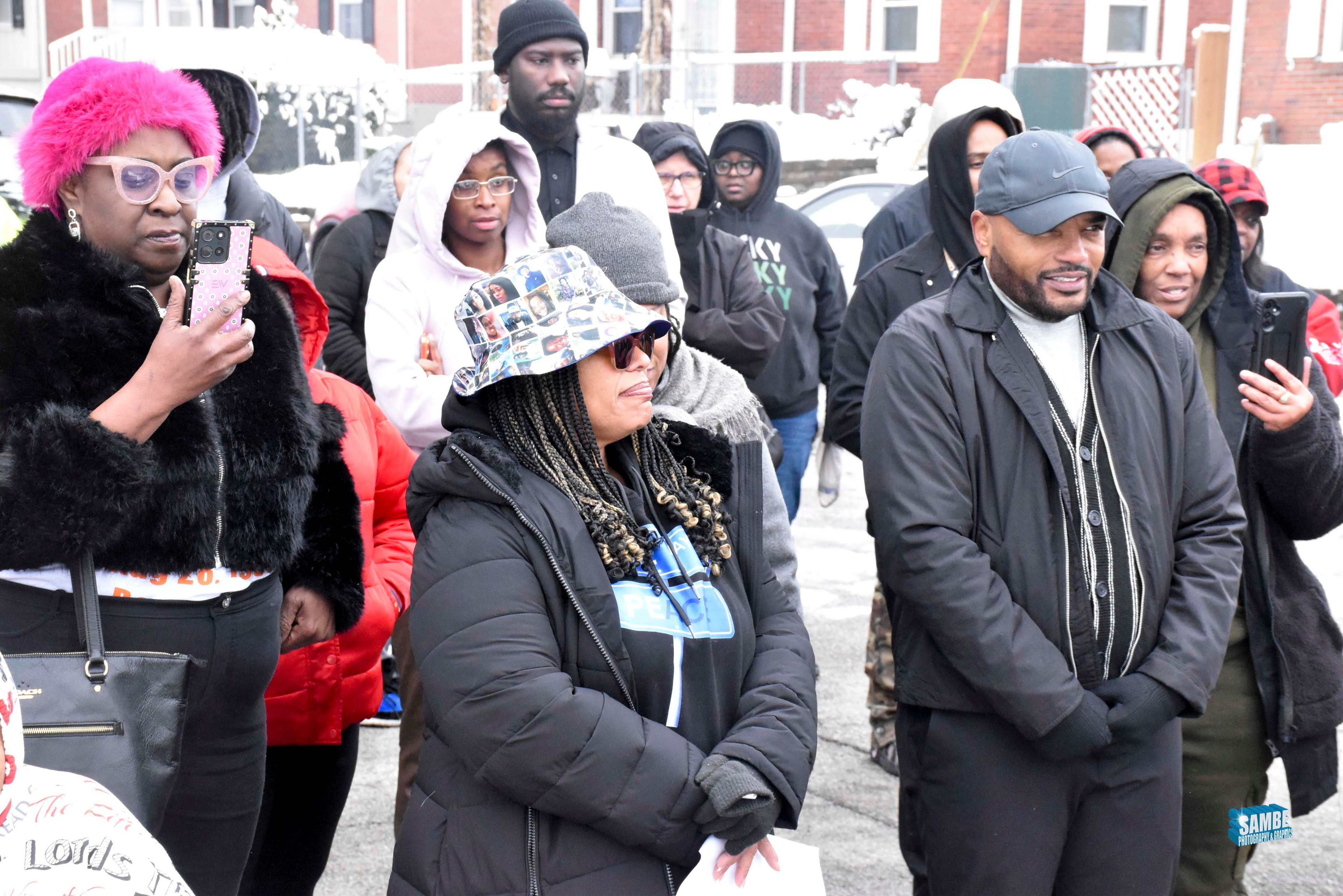 Community members standing together at outdoor ACE Project vigil in winter