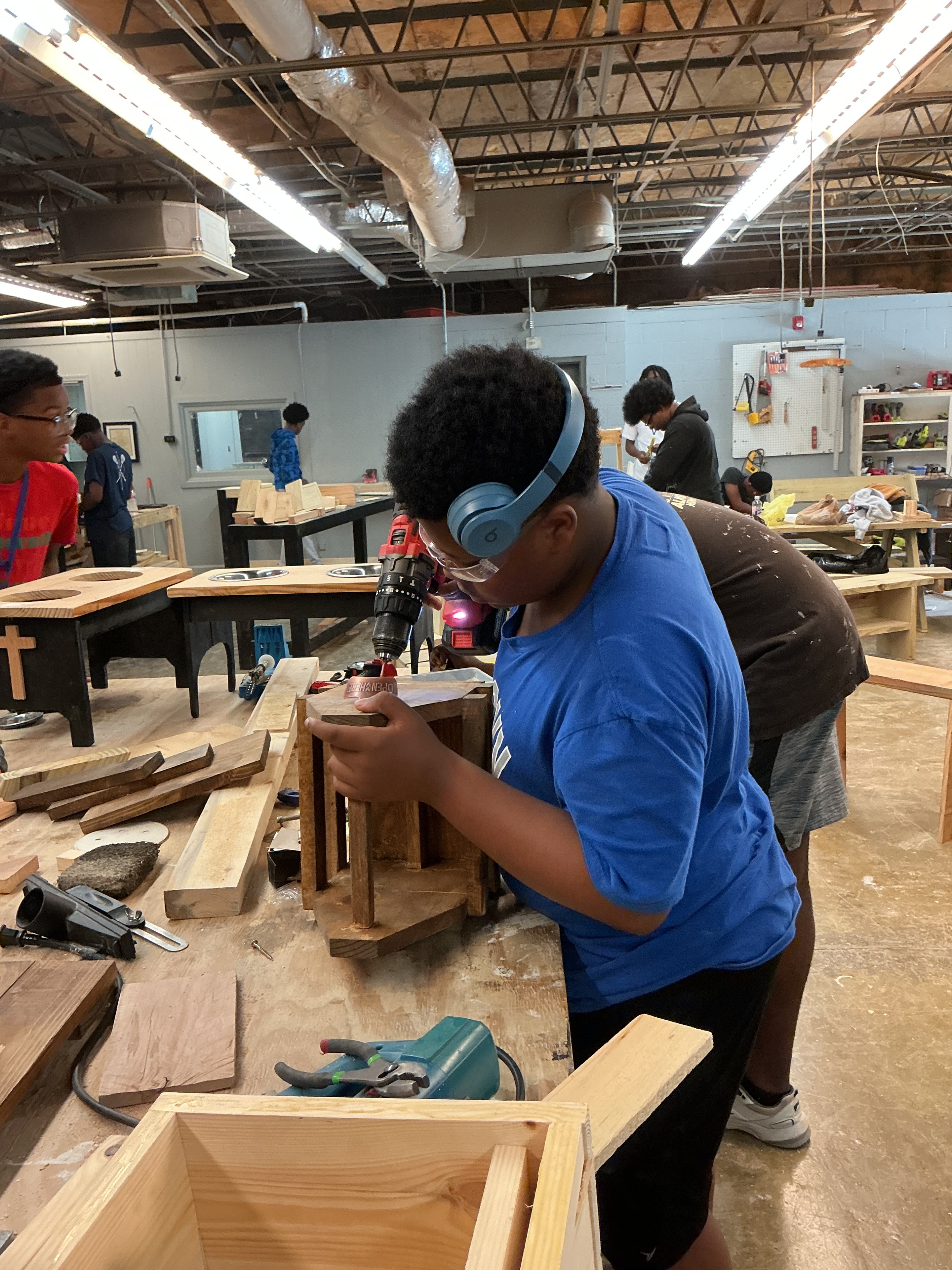 Youth participant drilling wood in the ACE Project Men in the Making woodshop